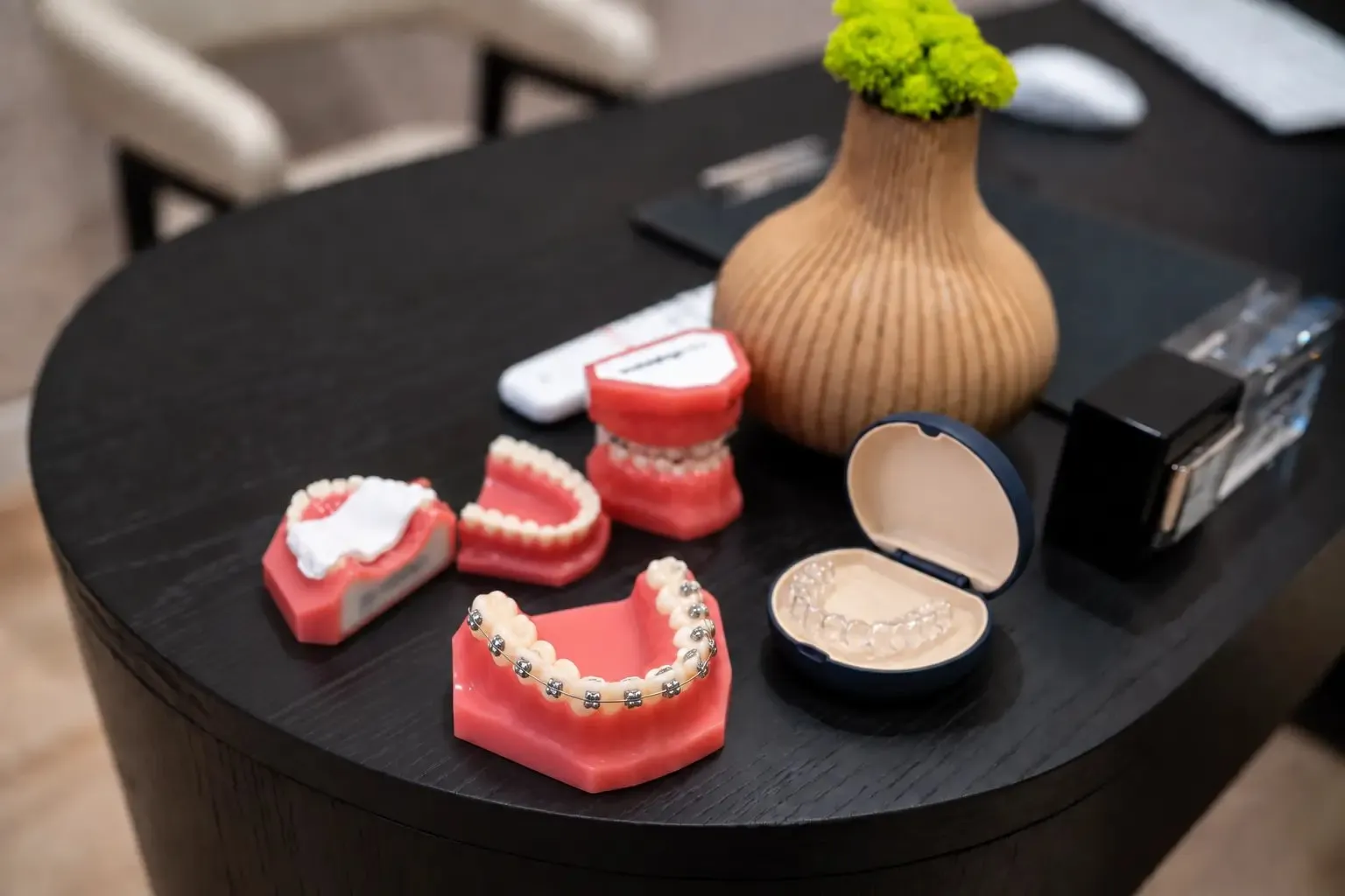 Braces and aligner models on the consultation table at SC Orthodontics