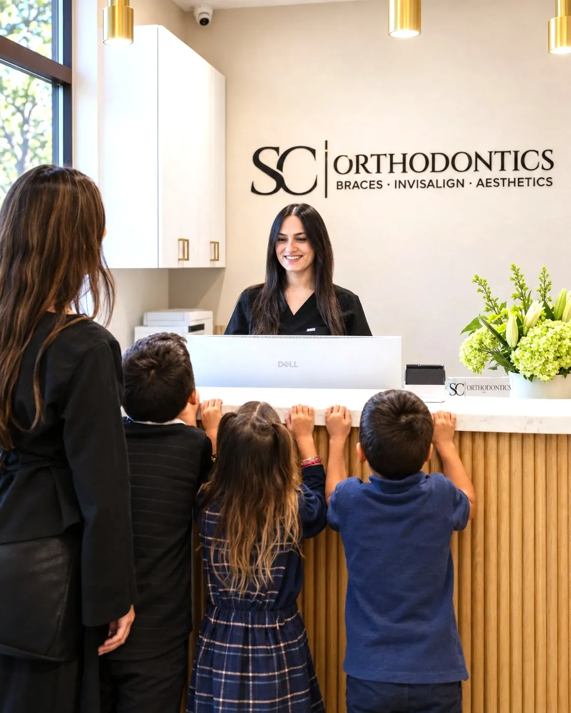 A mother and her three children checking in at the SC Orthodontics front desk