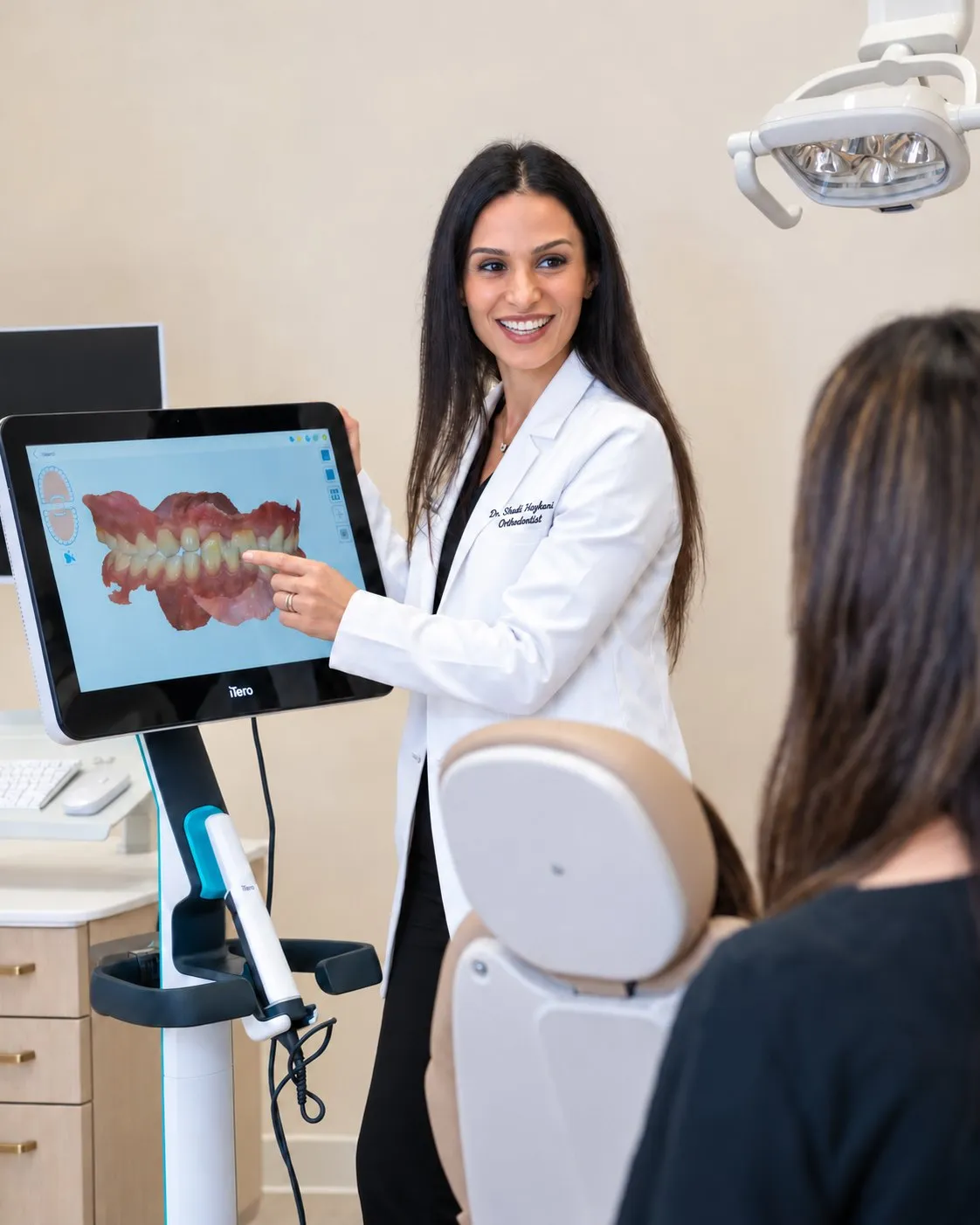 Dr. Haykani reviewing an aligner plan on screen with a patient