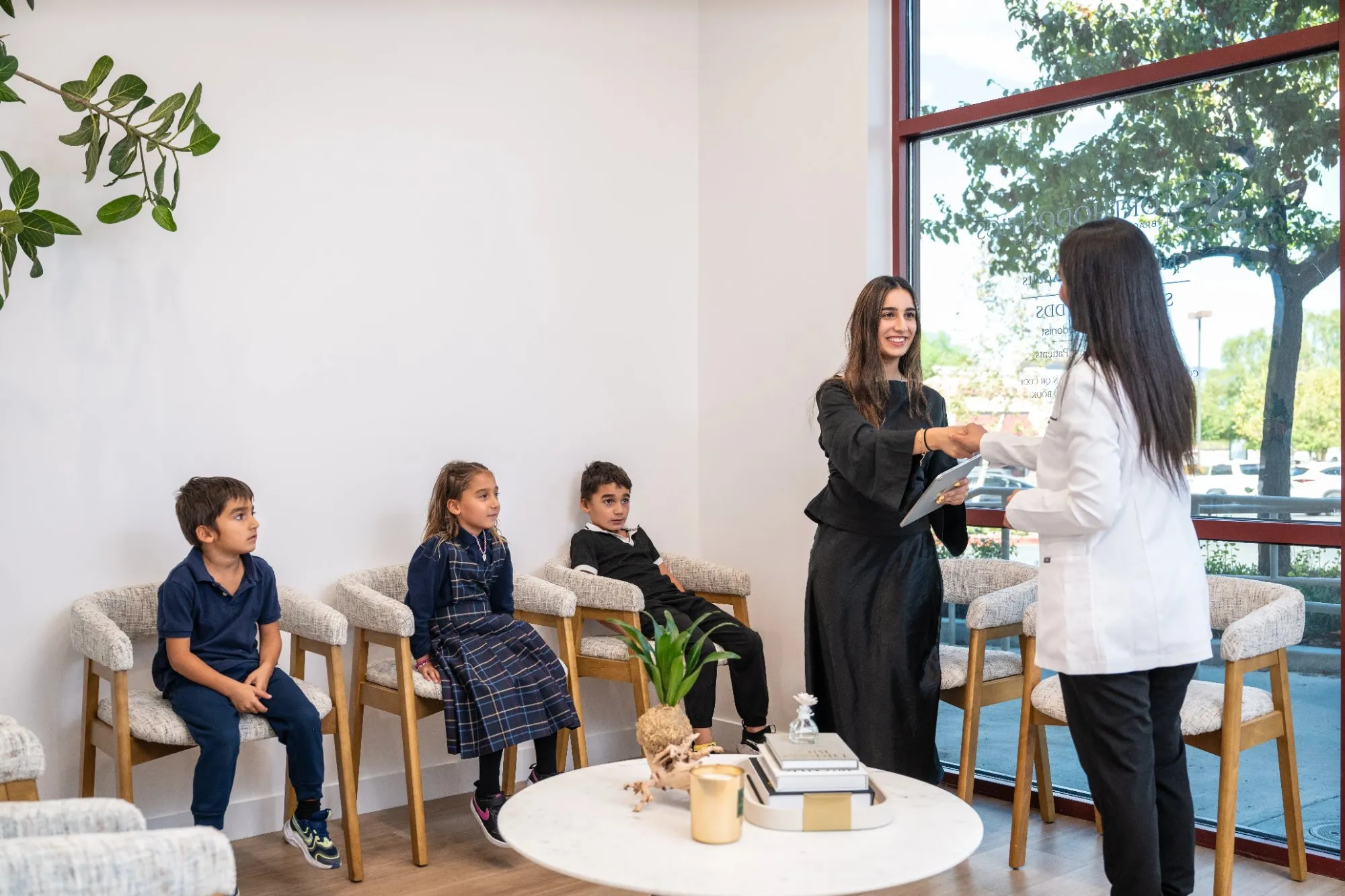 Dr. Haykani greeting a mother and her children in the waiting area