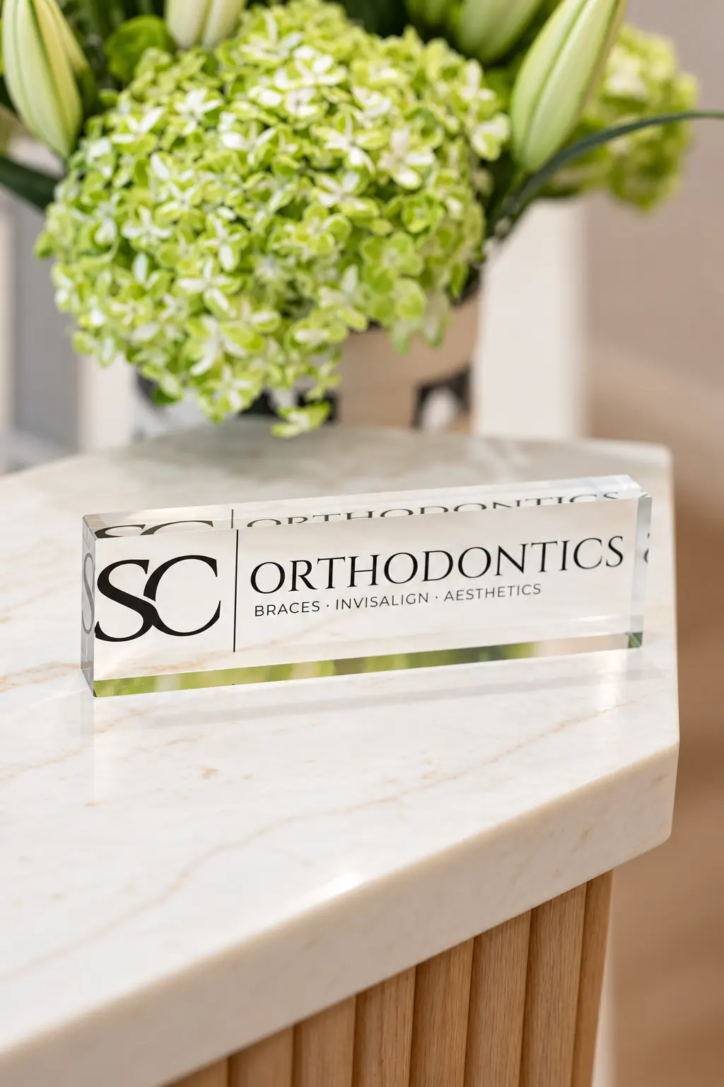 The SC Orthodontics acrylic sign with fresh flowers on the marble front desk