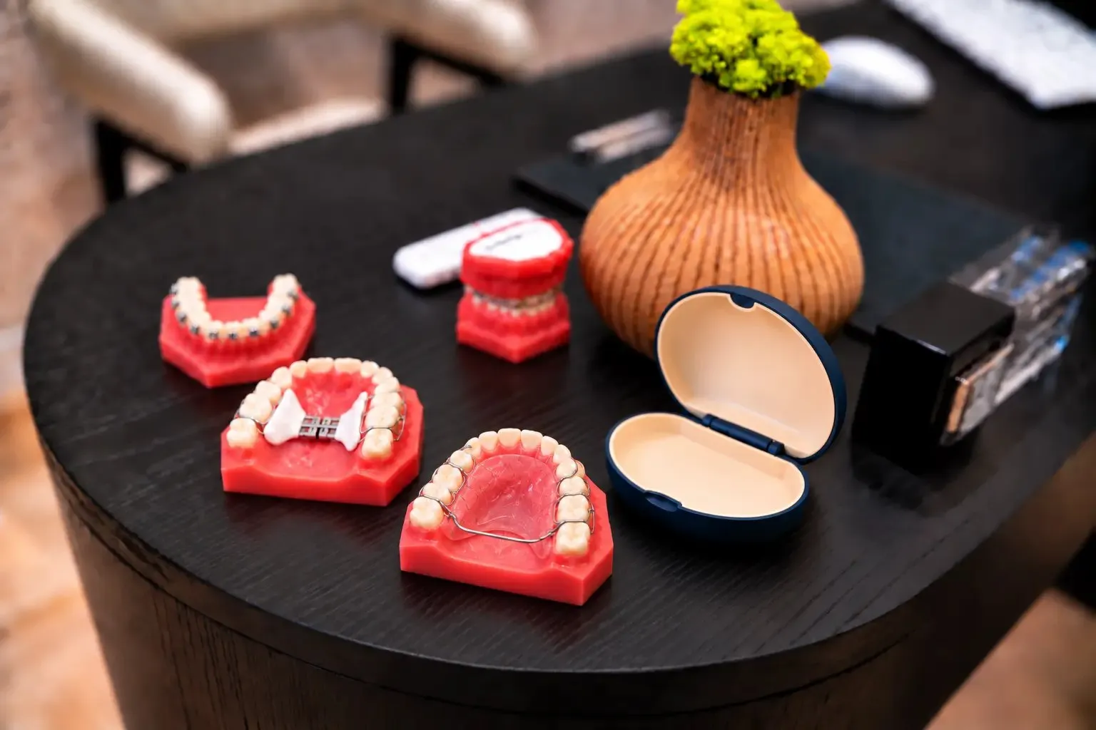 A Hawley retainer on a model beside its case at SC Orthodontics