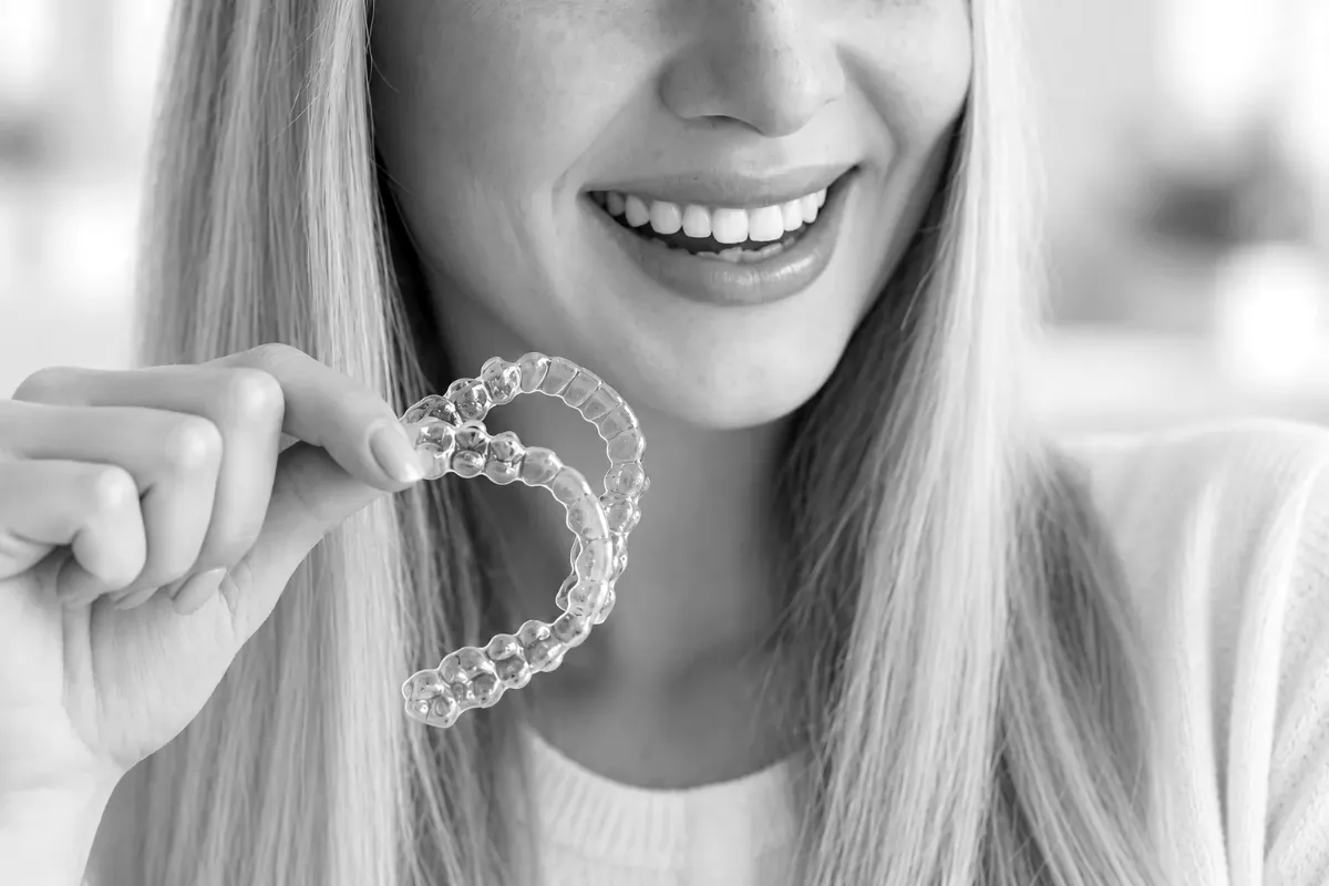 A patient holding a clear aligner tray